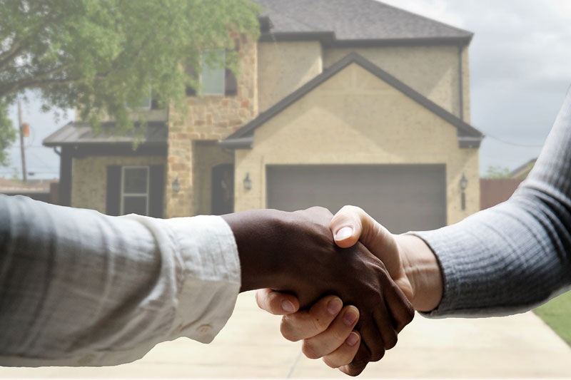 two people shaking hands after making a home purchase